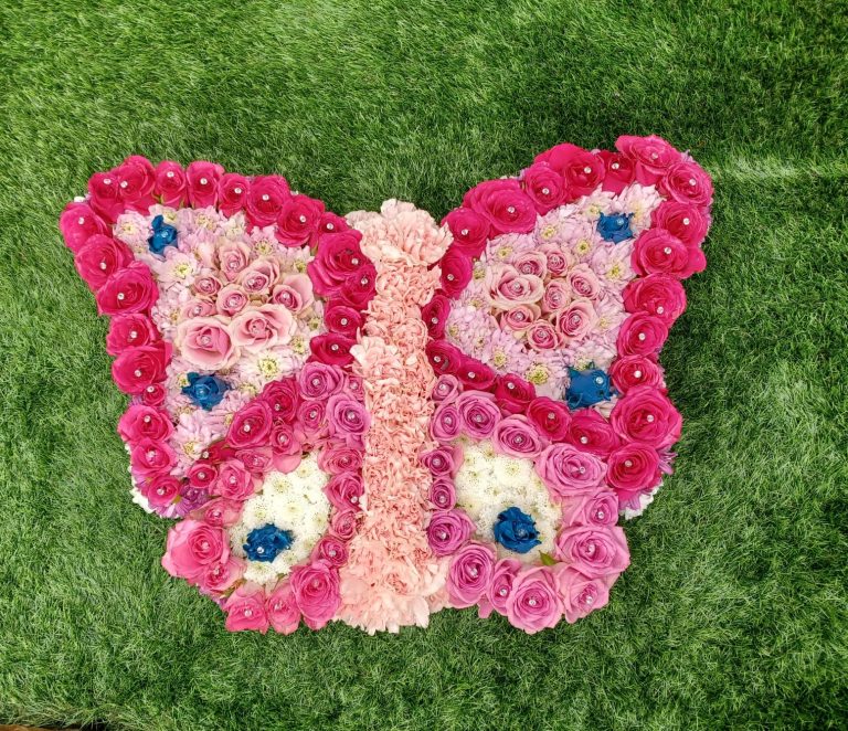 Butterfly Floral Tribute – Elegant Pink, Blue & White Funeral Flower Arrangement