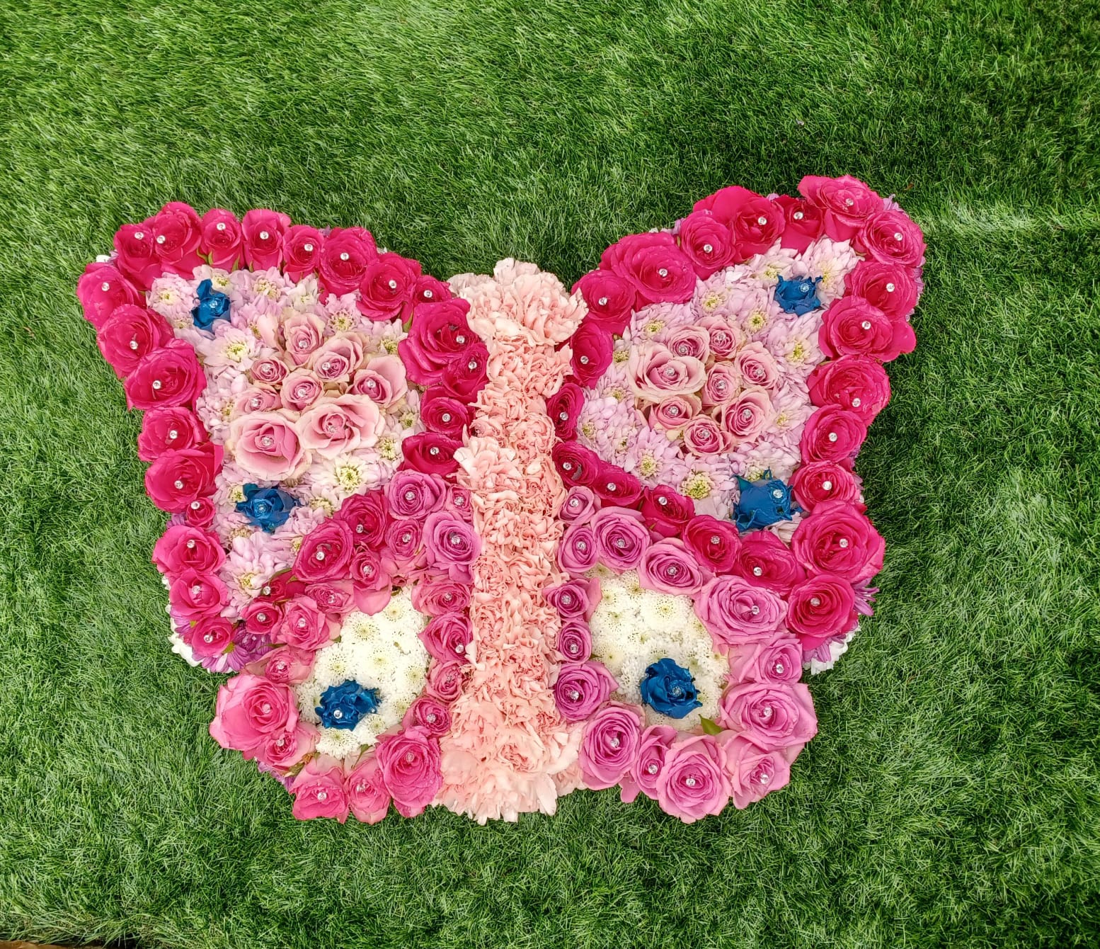 Butterfly Floral Tribute – Elegant Pink, Blue & White Funeral Flower Arrangement